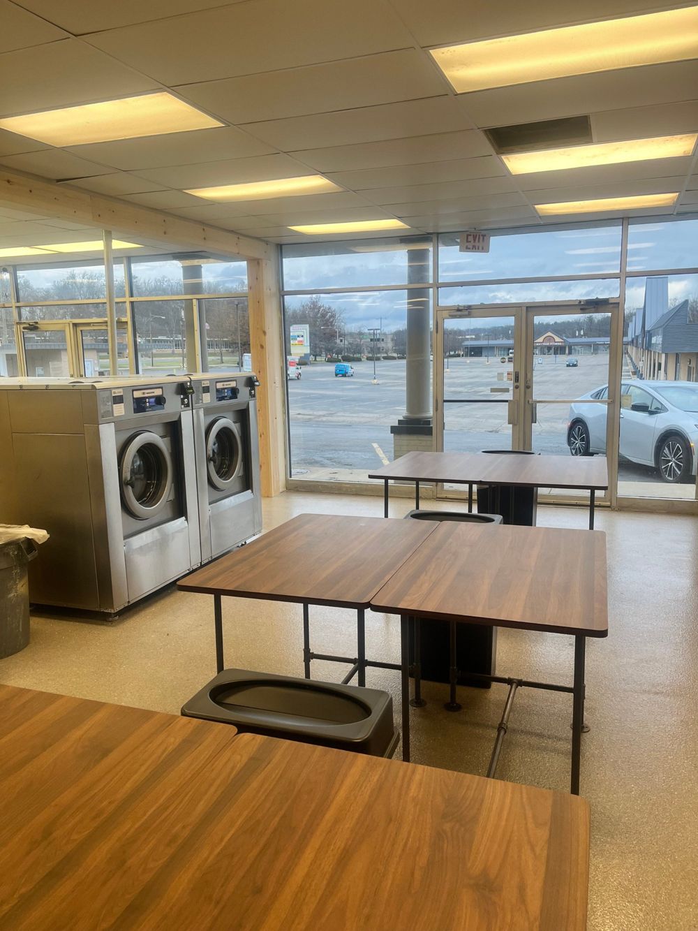 Wood folding tables by the front windows of Loveland Laundromat